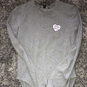 Long sleeve grey bodysuit says “maybe never”.